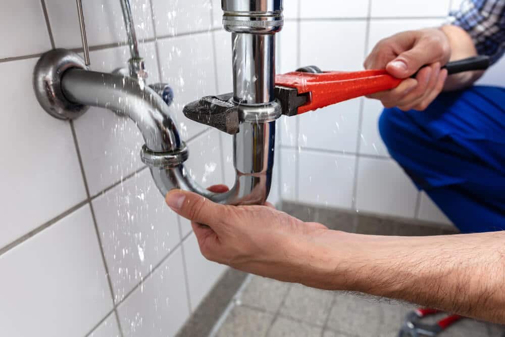 male-plumber-hand-repairing-sink-pipe-leakage